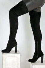Overknee Stiefel in schwarzem Stretchvelour mit 12 cm hohem Blockabsatz und 1 cm Mini-Plateau, sowie einem kurzem Reißverschluss.